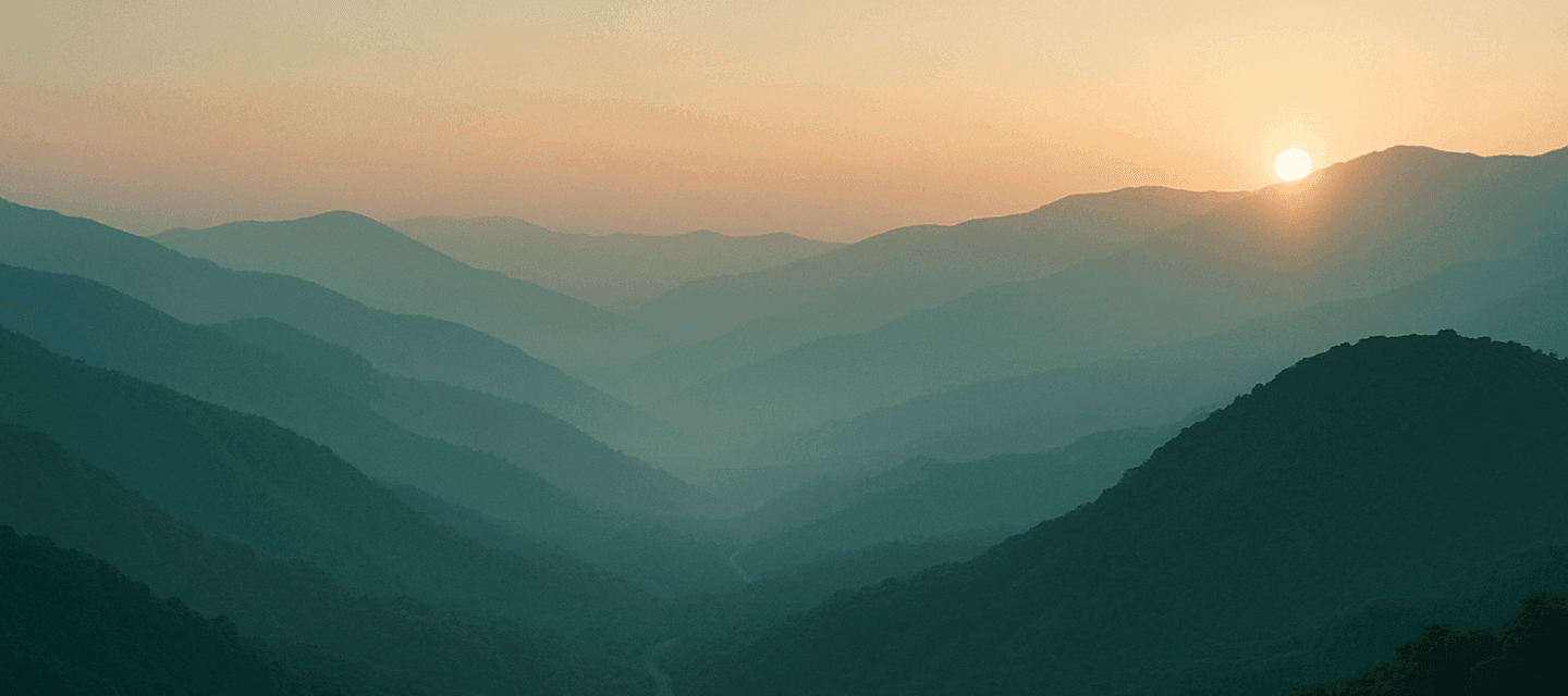 First light over layered ridge lines in the Western Ghats, a narrow road threading the valley below